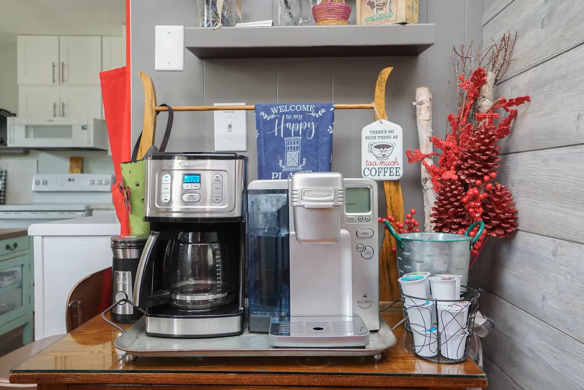 The image spotlights a cheerful coffee maker setup complete with cups, a water dispenser, and decorative accents. This inviting nook suggests the simple pleasure of morning coffee, a recurring theme in the written section, and hints at the thoughtful touches that make the kitchen feel like home.